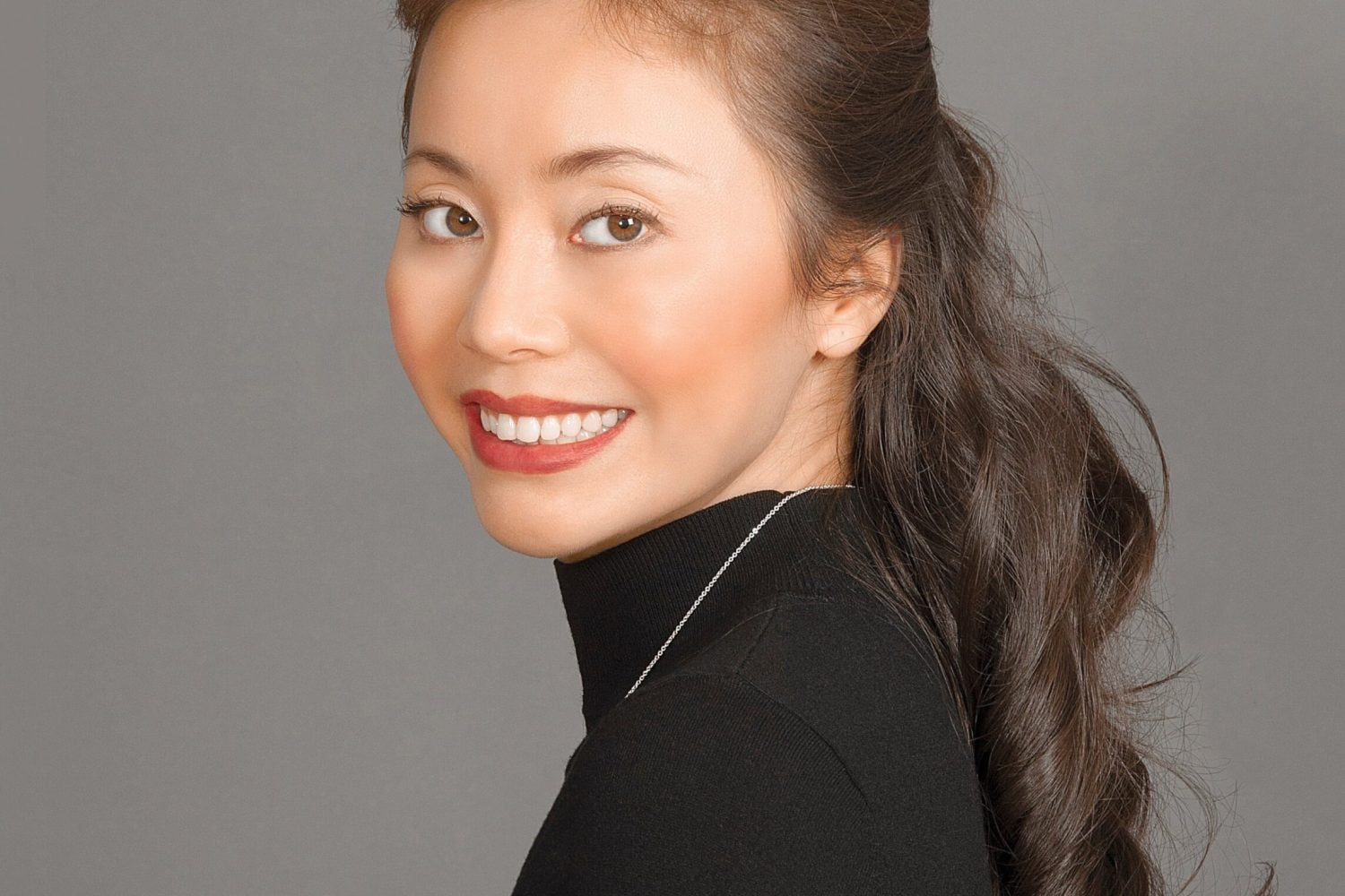 Dr. Yixiu Zheng, founder of Renaissance Medical, professional headshot smiling in a black turtleneck